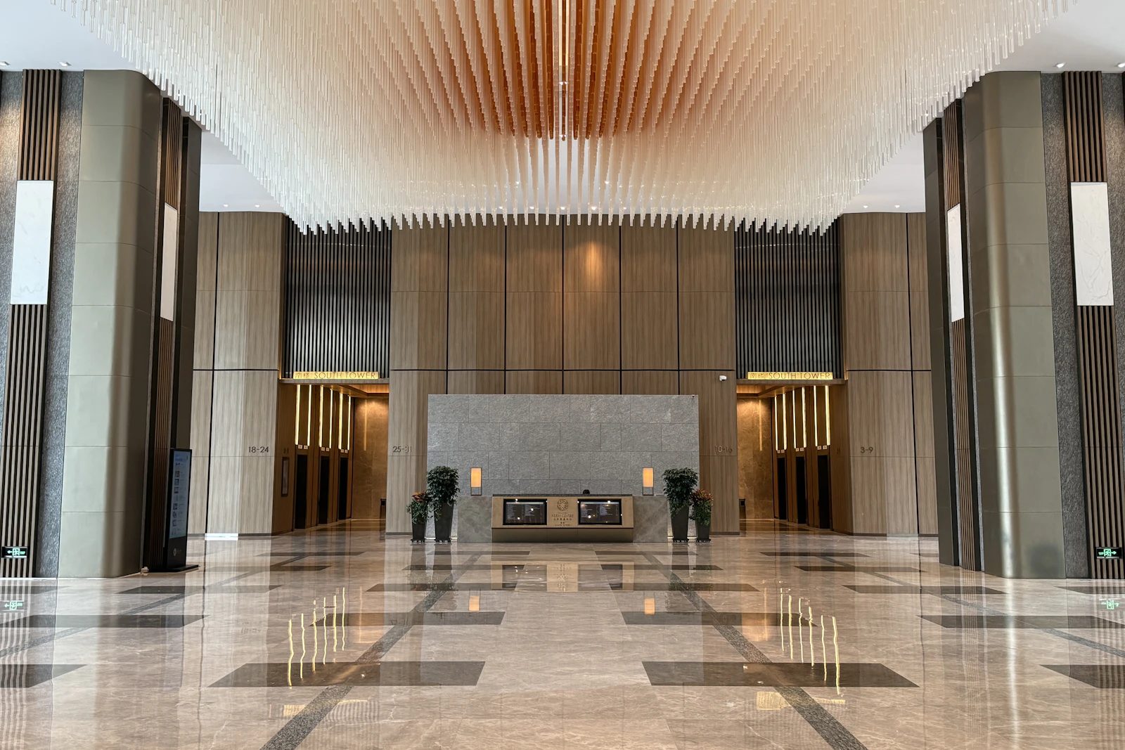 A tall marble-floored lobby with a reception desk at the far end.